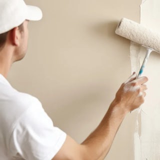 A photograph of a man painting a living room wall - homefix of Colorado Springs.
